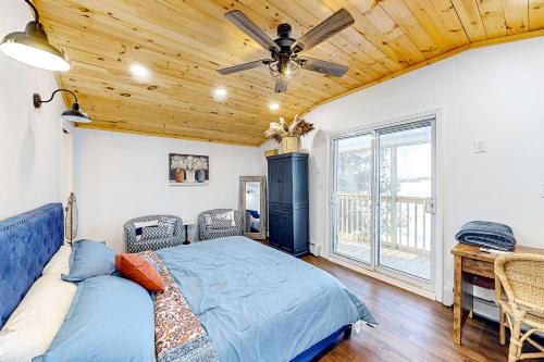 una camera con letto e ventilatore a soffitto di Last Lake Lodge a Madawaska