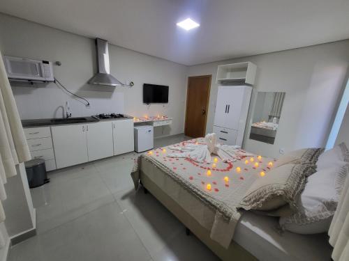 Un dormitorio con una cama grande con velas. en Hotel Avelar en Ribeirão das Neves