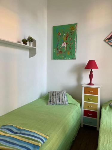 een slaapkamer met een groen bed en een nachtkastje bij Solar Das Marés in Fuzeta