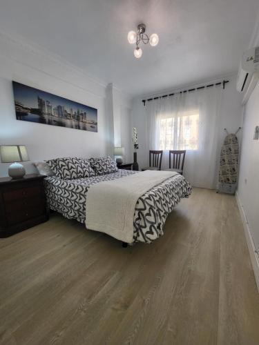 una camera con letto, cassettiera e tavolo di Appartement centre ville Malaga a Málaga