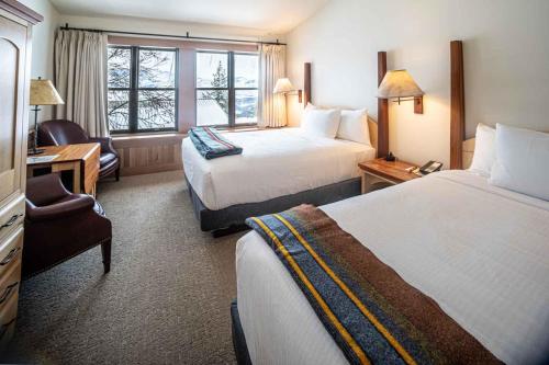 a hotel room with two beds and a chair at Sun Mountain Lodge in Winthrop