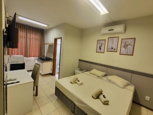 a hotel room with a bed and a bathroom at Hotel Avelar in Ribeirão das Neves