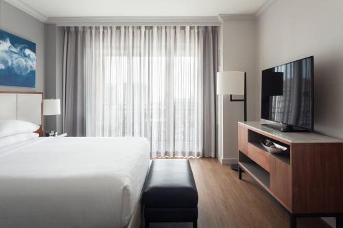 a hotel room with a bed and a flat screen tv at Tampa Marriott Water Street in Tampa