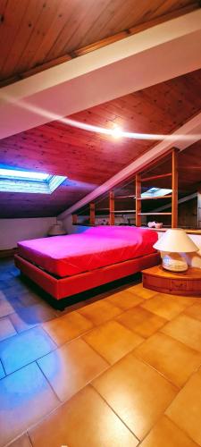 a bedroom with a red bed in a room at L'attico di Ovidio in Sulmona