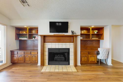 a living room with a fireplace and a flat screen tv at What a View in Bella Vista
