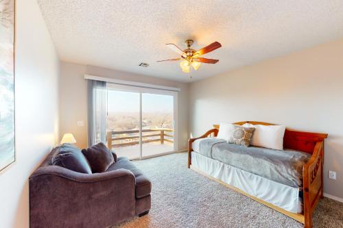 a bedroom with a couch and a ceiling fan at What a View in Bella Vista