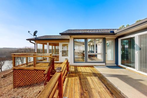 a home with a large deck with glass doors at What a View in Bella Vista