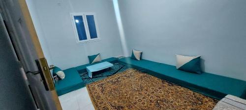 ein Zimmer mit einer blauen Bank in einem Zimmer in der Unterkunft النضافة الهدوُ والأمان in Taghit