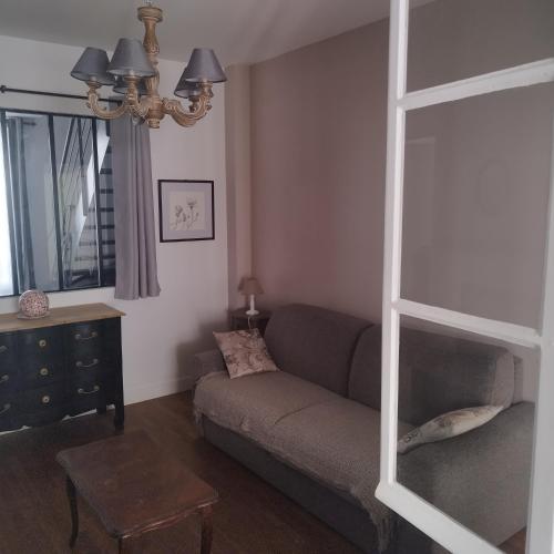 a living room with a couch and a table at Spacieux duplex en plein centre-ville de Fontainebleau in Fontainebleau
