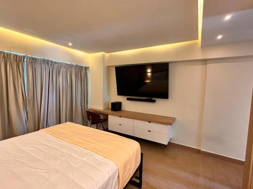 a bedroom with a bed and a flat screen tv at Villa Marbella by Potenza Rentals in Santo Domingo