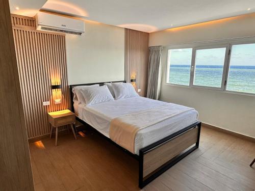 a bedroom with a bed with a view of the ocean at Villa Marbella by Potenza Rentals in Santo Domingo