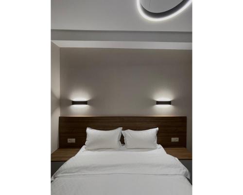 um quarto com uma cama branca e 2 almofadas em Crystal Loft Bakuriani - A406 em Bakuriani