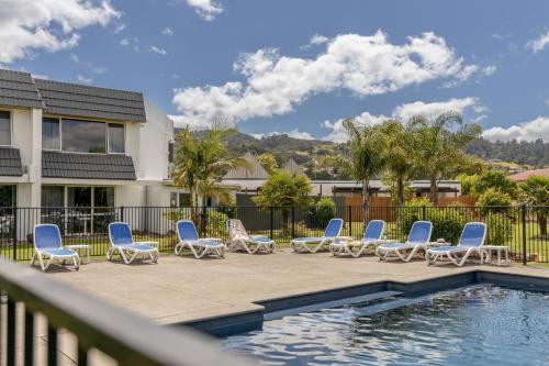 a group of chairs and a swimming pool at Avalon Motel Thames - Wenzel Motels in Thames