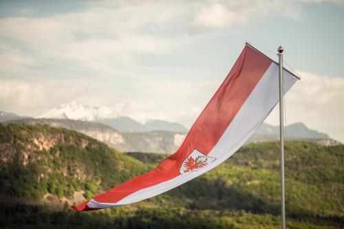 a red and white flag on top of a mountain at Romantik Hotel Jagdhof in Caldaro