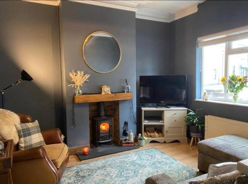 a living room with a fireplace and a mirror at Sea view Cottage in Cleethorpes