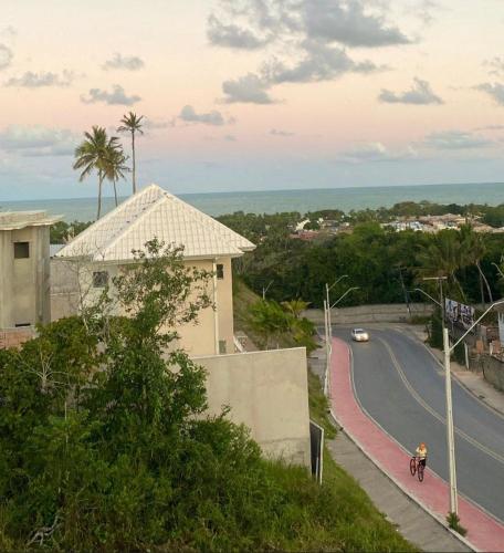 uma pessoa a andar de bicicleta por uma estrada em Apartamento Vista Mar em Porto Seguro