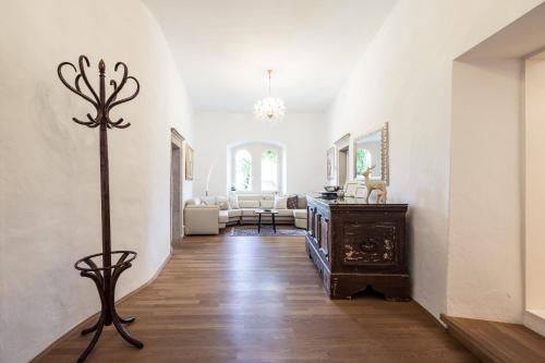 a hallway with a room with white walls and a wooden floor at Romantik Hotel Jagdhof in Caldaro