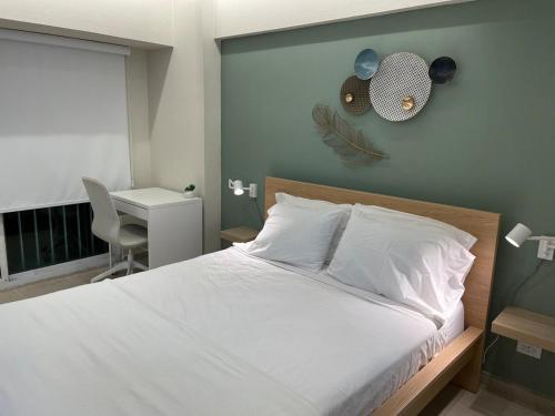 a bedroom with a white bed and a desk and a window at Villa Marbella by Potenza Rentals in Santo Domingo