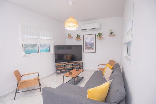 a living room with a couch and a tv at Villa Cervus Dianae in Kallithea Rhodes