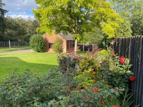 a garden with flowers in front of a fence at The Annexe at Gomo in East Winch