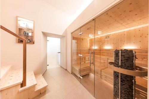 a bathroom with a shower and a glass wall at Romantik Hotel Jagdhof in Caldaro