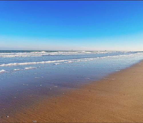 an empty beach with the ocean in the background at Manon Knokke - 3-kamer appartement met zeezicht aan het Rubensplein in Knokke-Heist