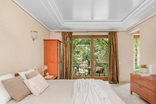 una camera bianca con letto e balcone di Jacuzzi apartments SELF CHECK-IN 24/7 by H&H a Vilnius