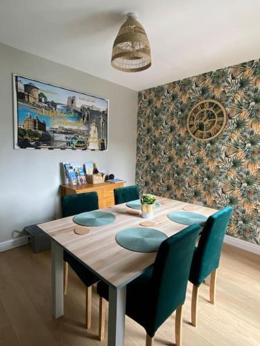 a dining room with a table and blue chairs at Sea Biscuit Cottage, Scarborough in Scarborough