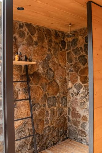 a room with a stone wall with a ladder at Hotel Cuatro Cuatros in Ensenada