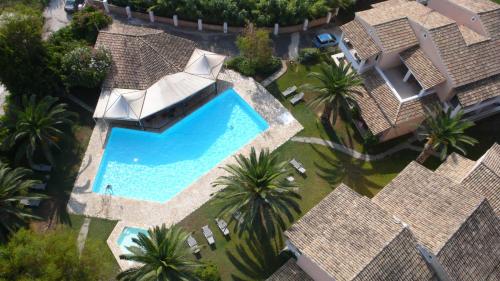 an overhead view of a swimming pool with palm trees at Folies Corfu Town Hotel Apartments in Corfu