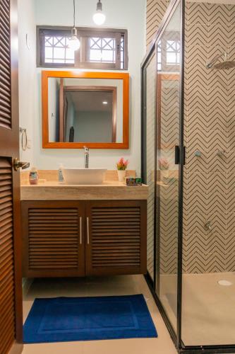 a bathroom with a sink and a mirror and a shower at Departamentos Sol, Mar y Arena in Isla Mujeres