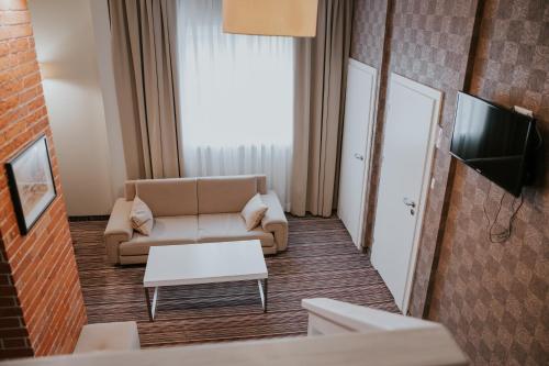 a living room with a couch and a table at Hotel Weranda Łopuszno in Łopuszno