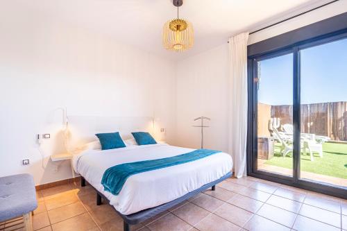a bedroom with a bed and a large window at Villa Colibri Azul in Lajares