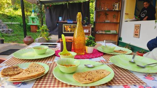 einen Tisch mit Teller und Schüsseln mit Essen drauf in der Unterkunft Wildernest retreat by ranjan in Aiju