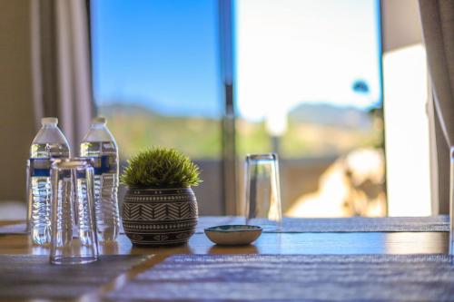 a table with glasses and a potted plant on it at ValZur Hospedaje: Suite Arces in Villa del Carbón