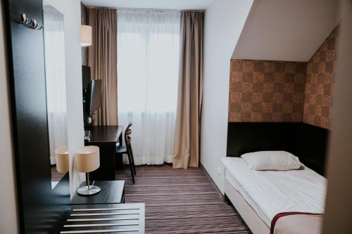 a hotel room with a bed and a desk and a desk at Hotel Weranda Łopuszno in Łopuszno