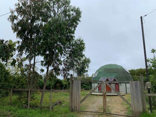 un granero con una cúpula verde detrás de una valla en Domo Malinche, en Lechagua