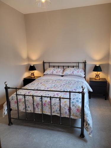 a bed in a bedroom with two lamps on tables at Maisie and Bea's cottage in Galway