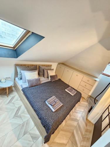 a large bed in a room with a skylight at Booking Apartment Rajiceva in Belgrade