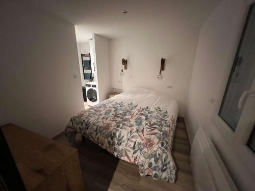 ein kleines Schlafzimmer mit einem Bett in einem Zimmer in der Unterkunft Appartement Cosy Gîte Le Marmont in Châtillon-sur-Seine