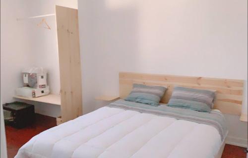 a white bedroom with a bed with blue pillows at Self-Check in Sunny & Charming Apt in Coimbra