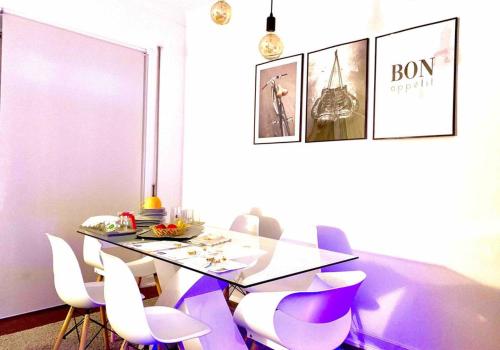 une salle à manger avec une table en verre et des chaises blanches dans l'établissement Self-Check in Sunny & Charming Apt, à Coimbra