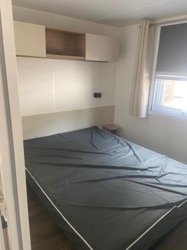 une chambre avec un lit dans une pièce dans l'établissement Mobilhome 4/6 personnes, à Valras-Plage