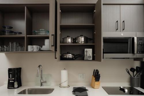 a kitchen counter with a sink and a microwave at WaterWalk Extended Stay by Wyndham Huntsville in Huntsville