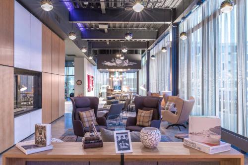 a salon with chairs and tables and windows at Moxy Aberdeen Airport in Dyce