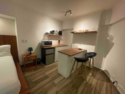 a small room with a bed and a kitchen with stools at Villa Marbella by Potenza Rentals in Santo Domingo