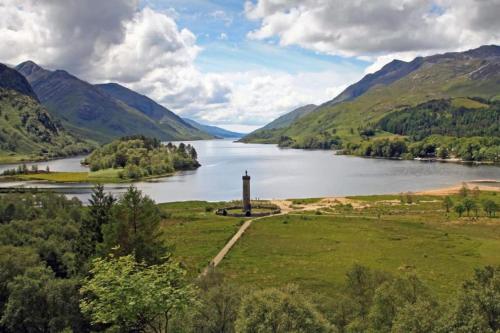 a view of a lake with a lighthouse in the middle at Fort William loft on shore front with amazing views in Caol