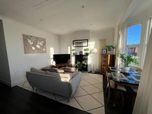 a living room with a couch and a table at Hill Grove 2 Bedroom Apartment in Leigh-on-Sea