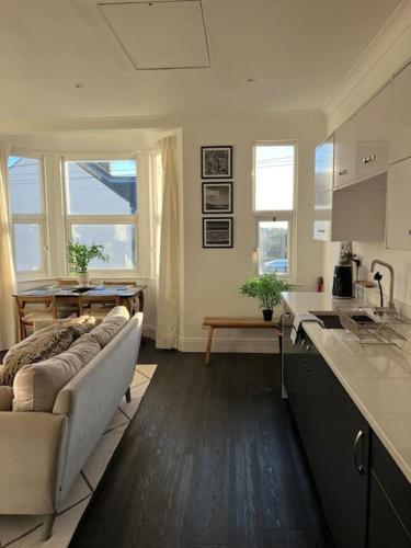 a kitchen and living room with a couch and a table at Hill Grove 2 Bedroom Apartment in Leigh-on-Sea