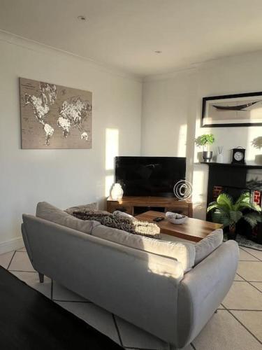 a living room with a couch and a table at Hill Grove 2 Bedroom Apartment in Leigh-on-Sea